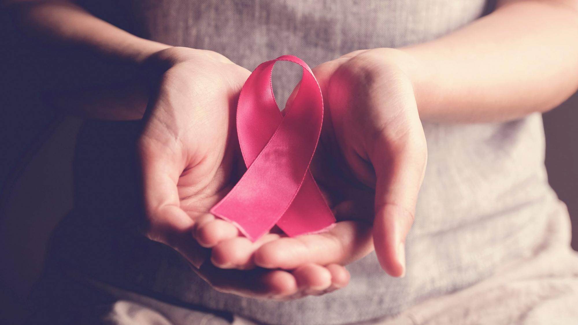 woman-holding-pink-ribbon-breast-cancer-awareness-scaled