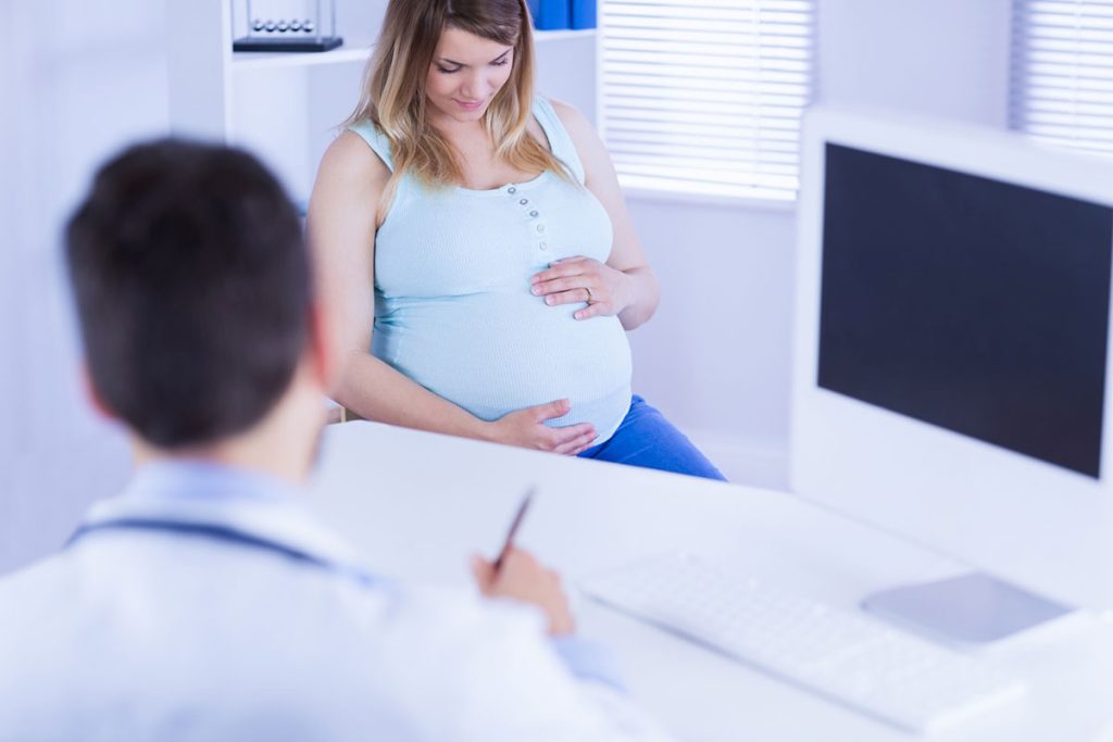 زنی باردار در حال مشورت با یک متخصص ژنتیک برای آگاهی از سلامت جنین خود