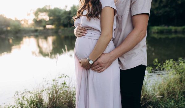 خانمی باردار در کنار همسرش با مشاوره ژنتیک حین بارداری فرزندی سالم باردار است