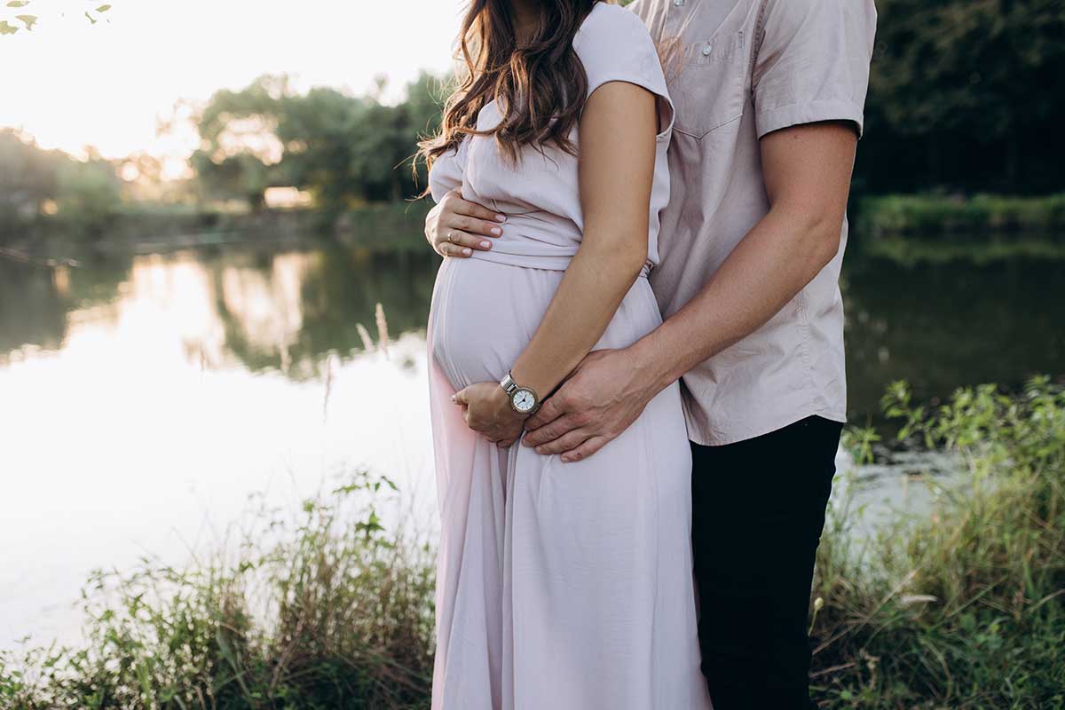 خانمی باردار در کنار همسرش با مشاوره ژنتیک حین بارداری فرزندی سالم باردار است